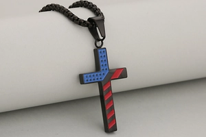 Detailed macro view of black stainless steel cross pendant with star and stripe pattern