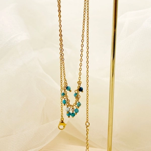 Détail du collier plaqué or 14K avec des perles de pierres bleues sur un présentoir