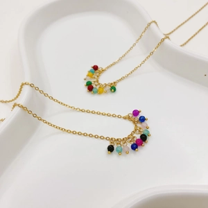 Détail du collier plaqué or 14K avec breloques en pierres naturelles colorées et perles sur blanc