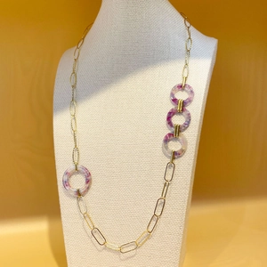 Long collier doré avec anneaux en acrylique marbré violet sur buste blanc