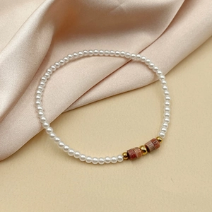 Détail d'un bracelet en perles d'eau douce avec perles en marbre rouge sur soie