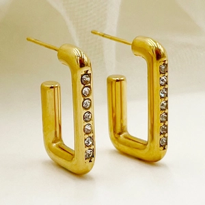Détail macro de boucles d'oreilles en U dorées avec micro-incrustations de zircon blanc