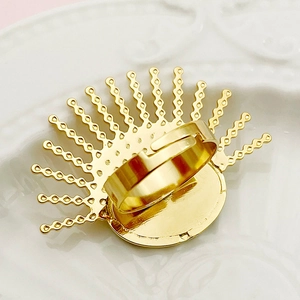 Primer plano de un anillo de flor dorada con diseño de abanico pulido y radiante
