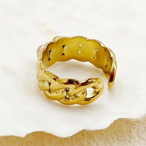 Détail d'une bague chaîne multicouche plaquée or avec un petit élément décoratif rose