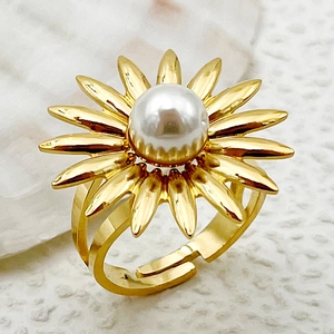 Detalle de un anillo de girasol dorado con perla blanca central y banda ajustable abierta