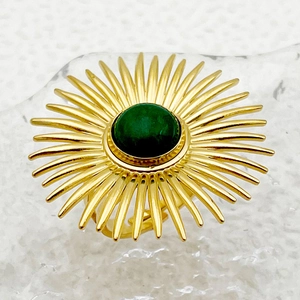 Primer plano detallado de un anillo vintage de sol dorado con piedra de malaquita verde