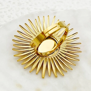 Detalle macro de un anillo solar dorado con textura radial y diseño de banda abierta