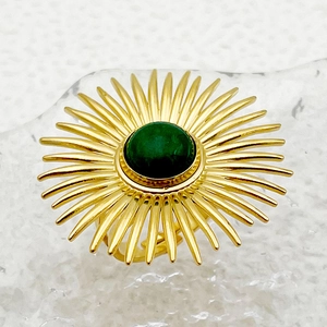 Anillo vintage de acero dorado con diseño de flor solar y gema verde