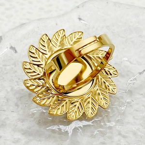 Detalle posterior de anillo de flor dorada con banda ajustable y texturas de pétalos