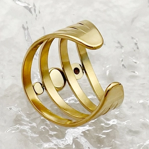 Vue macro détaillée d'une bague ouverte dorée multicouche avec trois bandes métalliques