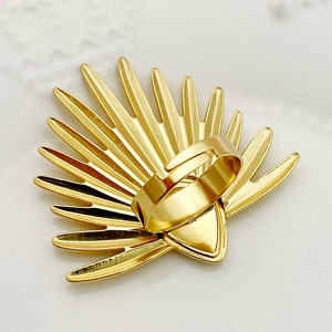 Detalle de anillo dorado en forma de abanico con diseño de hoja de palma y banda ajustable