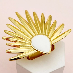 Primer plano de anillo dorado con diseño de abanico e incrustación de gota blanca