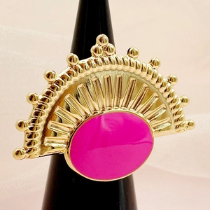 Vista detallada de un anillo bohemio dorado con esmalte magenta y diseño solar