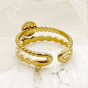 Détails d'une bague ouverte dorée double couche avec perles et lignes ondulées