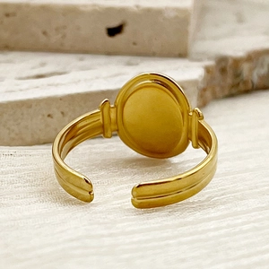 Detailweergave van de vergulde ovale ring met getextureerde band en open achterkant