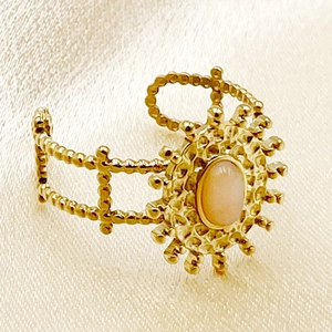 Détail de la bague soleil bohème avec pierre rose sur fond en soie claire