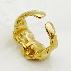 Détail de la bague ajustable dorée avec texture de lave irrégulière et métal organique