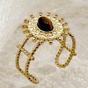 Détail d'une bague soleil vintage en or avec pierre brune et anneau ajustable