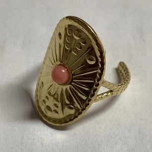 Macro-detail van vintage gouden zonnebloemring met roze edelsteen en gedraaide band