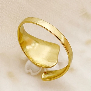 Détail macro d'une bague fleur plaquée or montrant la texture polie et l'anneau ajustable