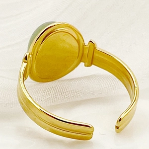 Gedetailleerde close-up van gouden verstelbare ring met ovale lichtgroene edelsteen