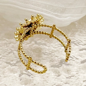 Gros plan d'une bague tournesol dorée vintage avec double anneau perlé sur dentelle