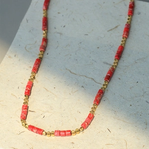 Collier de perles colorées avec colonnes en pierre rouge et perles dorées géométriques