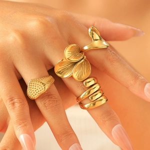 Three gold stainless steel rings featuring ginkgo leaf and spiral textures on a model hand