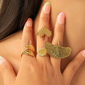 Ensemble de bagues dorées irrégulières feuilles et fleurs sur main au style luxueux