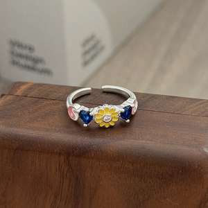 Details des verstellbaren Silberrings mit gelber Gänseblümchen und blauen Herzsteinen