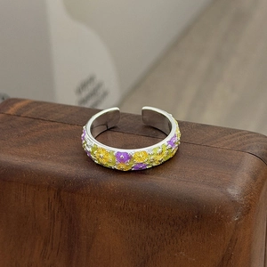 Nahaufnahme von Vintage Emaille-Blumenmustern auf einem silbernen offenen Ring