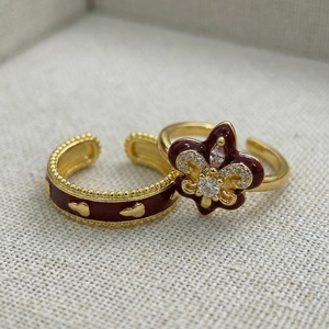 Detail of vintage burgundy enamel iris ring with zircon stones on textured background