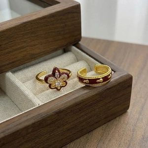 Macro detail of vintage fleur-de-lis rings with red enamel and golden carvings