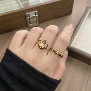 Detailed macro view of vintage burgundy enamel iris and heart rings worn on a hand