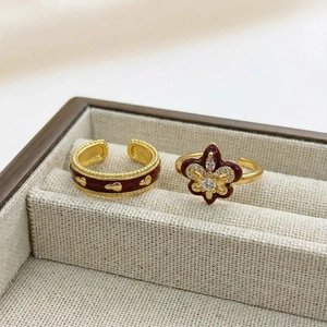 Macro shot of vintage gold rings with burgundy enamel heart and zircon fleur-de-lis