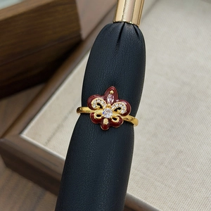 Macro view of vintage fleur-de-lis ring with red enamel and pavé stones on black leather