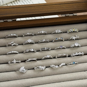 Macro display of diverse silver zircon rings featuring star leaf and floral designs