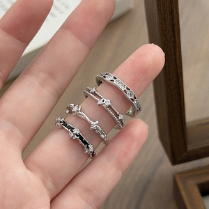 Close-up of four vintage silver rings featuring star motifs and zircon stone accents