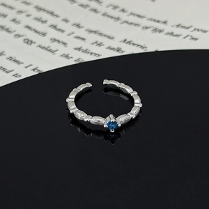 Macro view of silver adjustable ring with blue zircon and vintage leaf pattern
