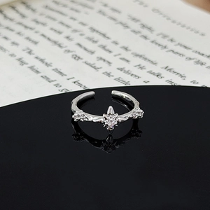 Detailed macro shot of an adjustable star ring with zircon on a black reflective surface