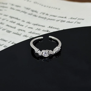 Close-up of sparkling star-leaf ring with cluster zircon stones on black mirror surface