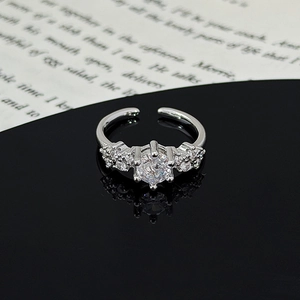 Macro detail of silver star leaf ring with zircon stones on a reflective surface