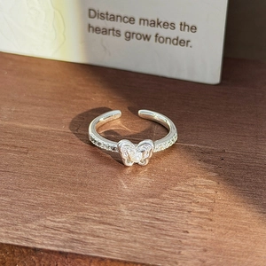 Detailed view of silver butterfly open ring with white pearl and sparkling zircon stones