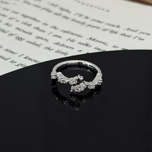 Detail of silver star ring with zircons on a black mirror surface and book background