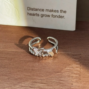 Detailed view of silver open ring with double-layer band and zircon butterfly elements