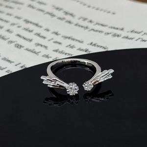 Macro view of silver star and leaf ring with zircon stones on a black reflective surface