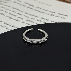 Detail of silver star leaf ring with zircon stones on an elegant vintage book background