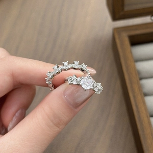 Detail of silver stackable rings set with sparkling zircon leaf and star patterns