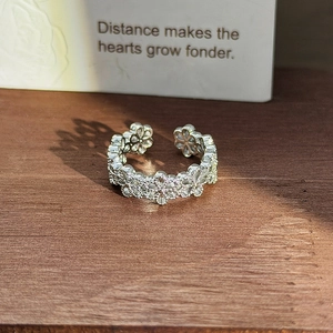 Detailed macro view of an adjustable silver flower ring set with shimmering zircons
