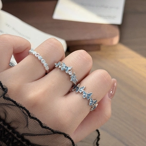 Detailed view of silver rings featuring blue butterfly charms and cubic zirconia on a model hand